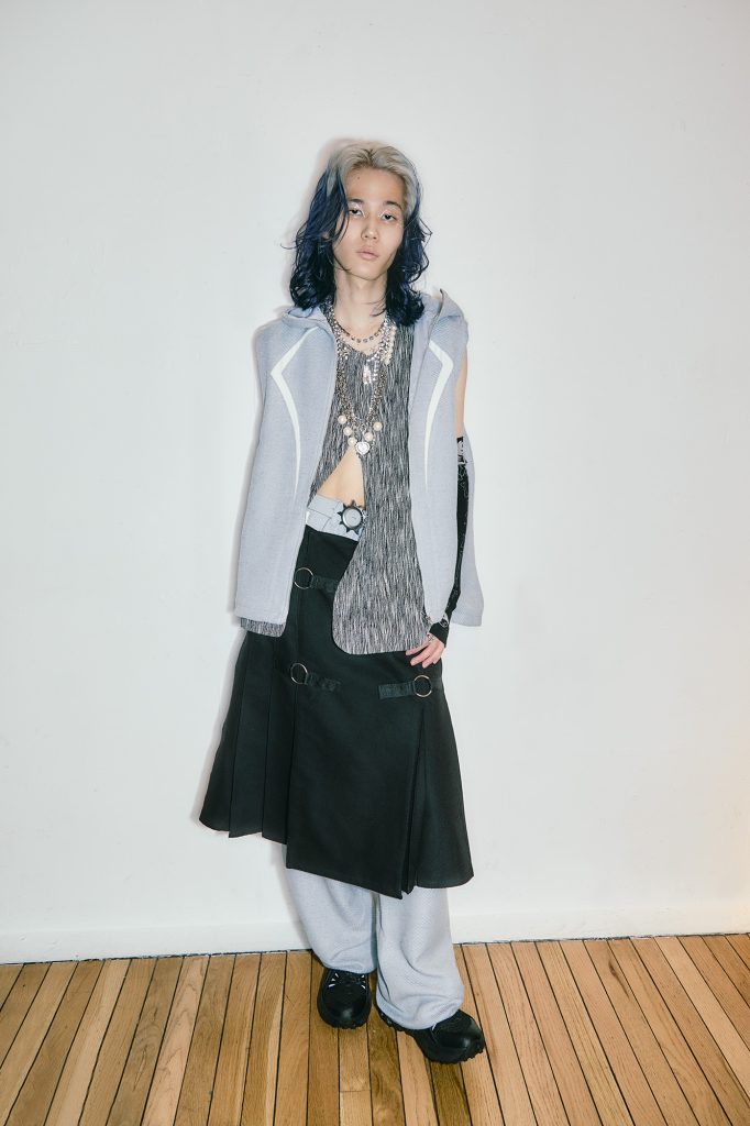 フーディー、パンツ／jichoi、中に着たベスト／ceimou（共に MATT.） スカート／Andersson Bell（SSENSE）グローブ／FUGUIHUA（9FOX Showroom） パールネックレス ／PAMEO POSE ビジューネックレス ／neith.（neith.tokyo） スニーカー／ORKLEY （ルックスオティカジャパン カスタマーサービス）